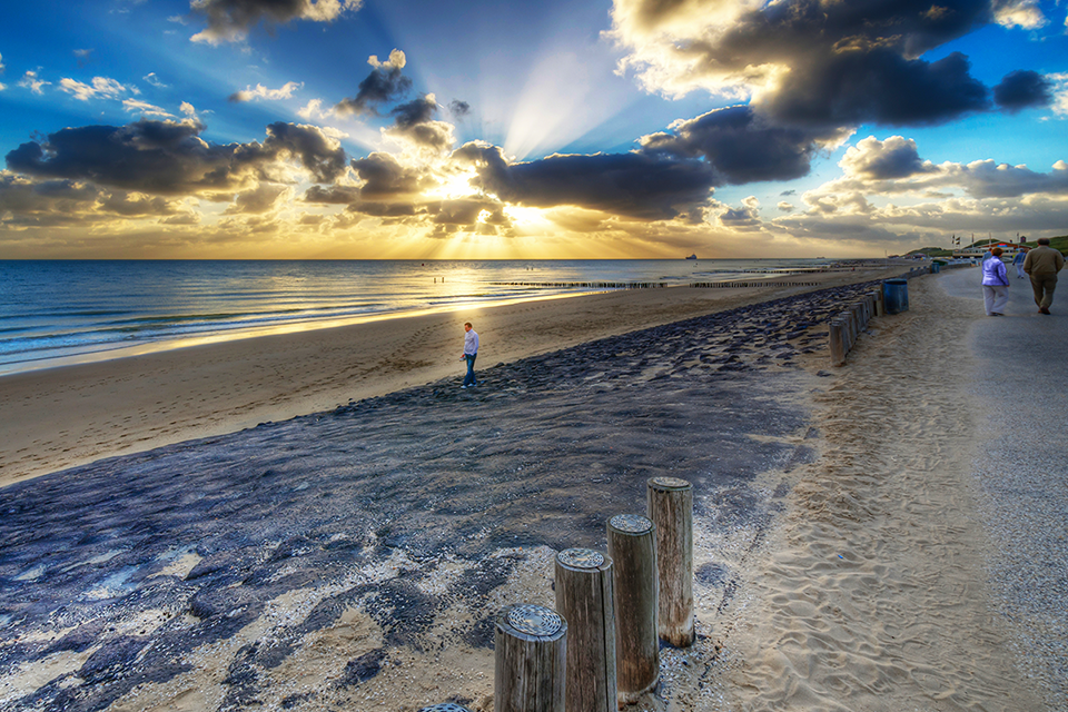 Prachtige zonsondergang op het strand van Zoutelande op een bewolkte dag